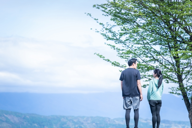 屋外で運動する爽やかな男女の後ろ姿